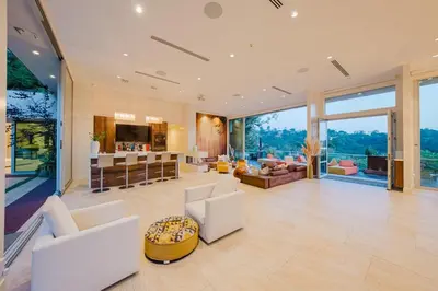 an open living room with white furniture and large windows at Zen Estate in Los Angeles