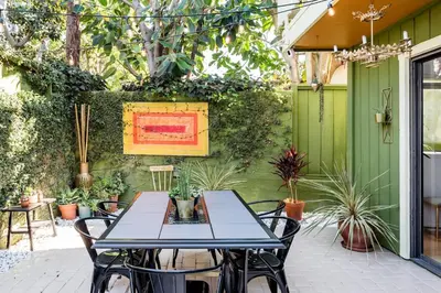 a table and chairs on a patio with plants at Silver Triangle Oasis with Verdant Backyard in Los Angeles