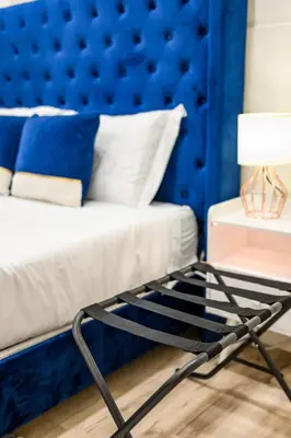 a bed with a blue headboard and a table with a lamp at 1 Block to Beach Heaven Chic 2BD in Manhattan Beach