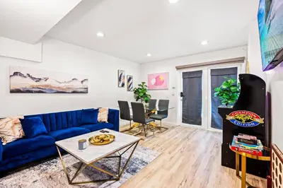 a living room with a blue couch and a table at 1 Block to Beach Heaven Chic 2BD in Manhattan Beach