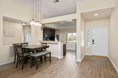 a dining room and kitchen with a table and chairs at Relaxing 4BR 2BA Sleeps 8 Family Friendly in Bakersfield