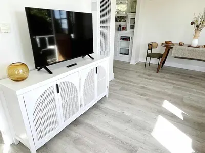 a living room with a television on a white entertainment center at Montecito Heights Hideaway in Los Angeles