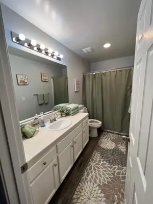 a bathroom with a sink and a toilet and a mirror at Cadbury 4BR Outdoor Kitchen Sleeps 8 Peaceful in Bakersfield