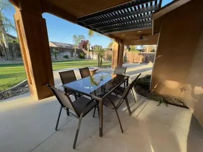 a patio with a glass table and chairs at Cadbury 4BR Outdoor Kitchen Sleeps 8 Peaceful in Bakersfield