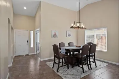 a dining room with a table and chairs at 4bdrm 2bath Modern Getaway KING Bed Sleeps 8 in Bakersfield