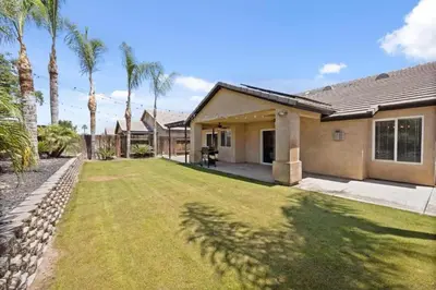 a house with a yard with palm trees at 4bdrm 2bath Modern Getaway KING Bed Sleeps 8 in Bakersfield