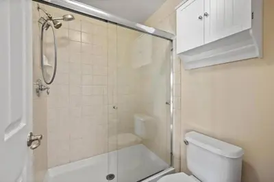 a small bathroom with a shower and a toilet at 4bdrm 2bath Modern Getaway KING Bed Sleeps 8 in Bakersfield