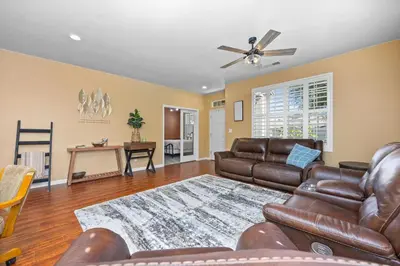 a living room with leather furniture and a ceiling fan at Luxury Gated Retreat Golf Course Views Sleeps 8 in Bakersfield