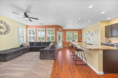 a living room with a couch and a kitchen at Luxury Gated Retreat Golf Course Views Sleeps 8 in Bakersfield