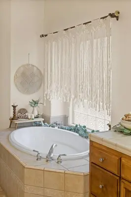 a bath tub in a bathroom with a window at Spacious 4BR 3BA Home KING Suite Pool Sleeps 8 in Bakersfield