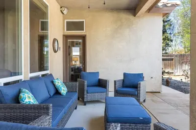 a patio with blue couches and chairs at Spacious 4BR 3BA Home KING Suite Pool Sleeps 8 in Bakersfield
