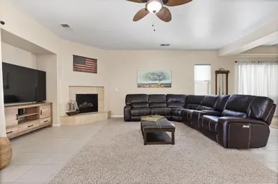 a living room with a leather couch and a flat screen tv at Stylish Silver Falls 4BR KING Master Game Room in Bakersfield