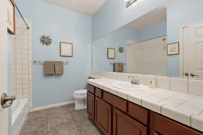 a bathroom with a sink and a toilet and a mirror at Windward Bay Executive 3BR Office Home Pool in Bakersfield