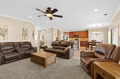 a living room with leather furniture and a ceiling fan at Windward Bay Executive 3BR Office Home Pool in Bakersfield