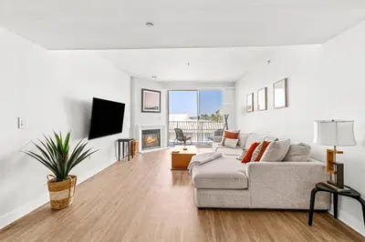 a white living room with a couch and a tv at Acacia Waterfront Marina Views Pool Gym Jacuzzi And Sauna in Los Angeles