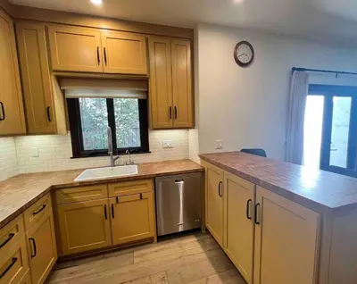 a kitchen with yellow cabinets and a sink and a window at Beachwood in Los Angeles