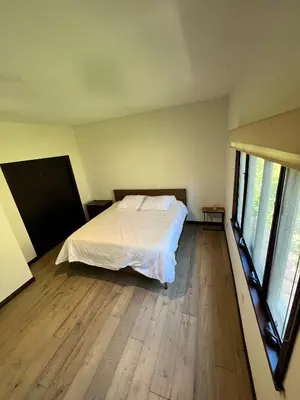 a bedroom with a bed and wooden floors and windows at Beachwood in Los Angeles