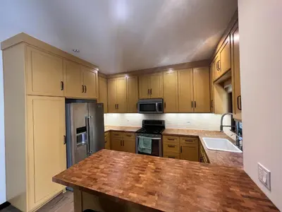 a kitchen with wooden cabinets and a stainless steel refrigerator at Beachwood in Los Angeles