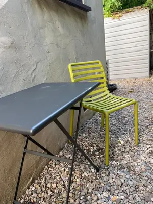 a table and yellow chair sitting next to a building at Beachwood in Los Angeles