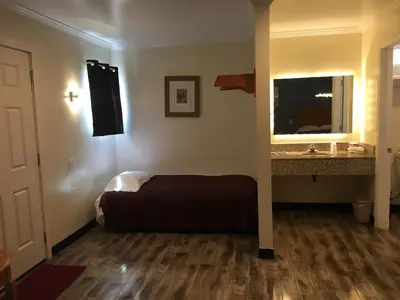a bedroom with a bed and a sink and a mirror at Lincoln Park Motel in Los Angeles