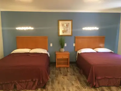 two beds in a room with blue walls at Lincoln Park Motel in Los Angeles