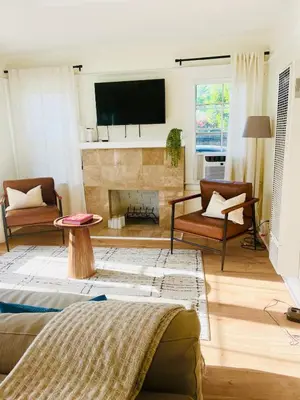a living room with a fireplace and a flat screen tv at Cozy Hollywood Cottage - Walk to Larchmont Village in Los Angeles