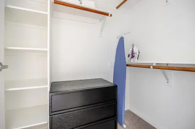 a walk in closet with a black dresser at Blueground Pasadena pool AC nr City Hall LAX-1315 in Los Angeles