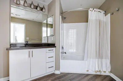 a bathroom with a tub and a sink and a shower at Blueground Pasadena pool AC nr City Hall LAX-1315 in Los Angeles