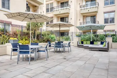 a patio with tables and chairs and umbrellas at Blueground Pasadena pool AC nr City Hall LAX-1315 in Los Angeles