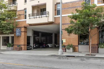 a building with cars parked in a parking lot at Blueground Pasadena pool AC nr City Hall LAX-1315 in Los Angeles