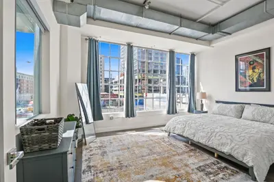 a bedroom with a bed and large windows at Stunning DTLA Gem 2 bed with pool, gym and parking in Los Angeles