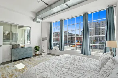 a bedroom with a large bed and large windows at Stunning DTLA Gem 2 bed with pool, gym and parking in Los Angeles