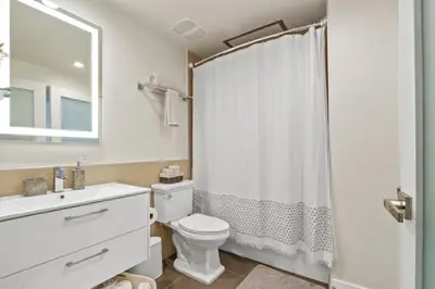 a bathroom with a toilet and a sink and a shower at Stunning DTLA Gem 2 bed with pool, gym and parking in Los Angeles