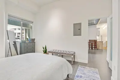 a white bedroom with a white bed and a table at Stunning DTLA Gem 2 bed with pool, gym and parking in Los Angeles