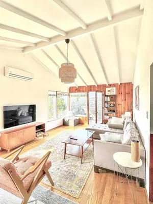 a living room with a couch and a table at Serene & beautiful bohemian hilltop retreat in Glendale
