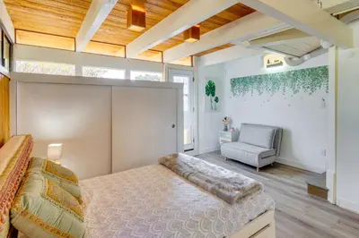 a bedroom with a large bed and a chair at Stroll to Beach and Pepperdine Airy Malibu Studio in Malibu