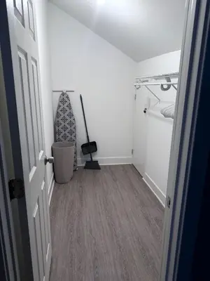 a room with a hallway with white walls and wood floors at The Jazz Room - Executive Suite Downtown Riverside in Riverside
