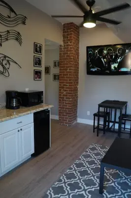 a living room with a kitchen with a brick wall at The Jazz Room - Executive Suite Downtown Riverside in Riverside