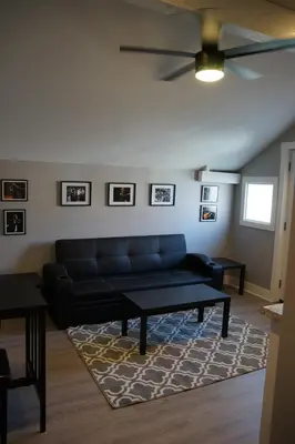a living room with a black couch and a table at The Jazz Room - Executive Suite Downtown Riverside in Riverside