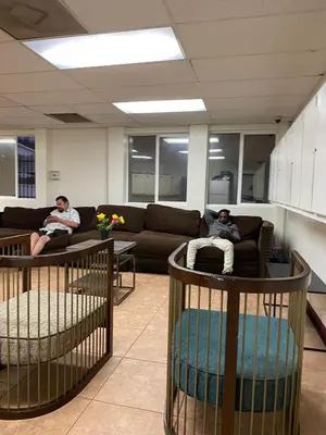 two people sitting on couches in a living room at Van Nuys Vibe in Van Nuys County Court Heliport