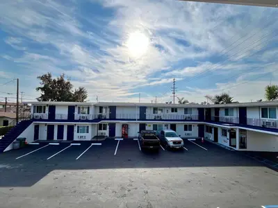 a building with two cars parked in a parking lot at Del Aire Inn LAX in Inglewood