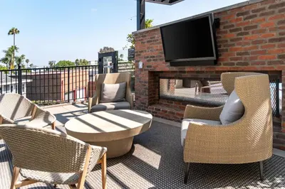 a patio with chairs and a fireplace with a tv at Luxury 2 Bedroom 2 Bathroom Residence With Fitness and Outdoor Pool in Los Angeles