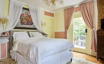 a bedroom with a large white bed with a chandelier at Hollywood Deluxe Homestay in Los Angeles