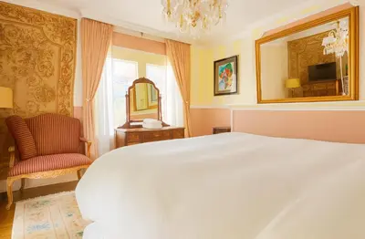 a bedroom with a bed and a chair and a mirror at Luxurious Hollywood Homestay in Los Angeles
