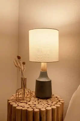 a lamp on a table with a vase of flowers at Little Wolf Lodge Modern Cabin at Lake Gregory in Crestline