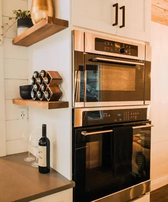 a kitchen with two ovens and a bottle of wine at Little Wolf Lodge Modern Cabin at Lake Gregory in Crestline