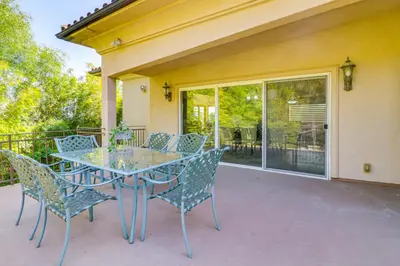 a patio with a table and chairs on a balcony at Play, Swim and Unwind Luxe Los Angeles Oasis! in Chatsworth Lake Manor