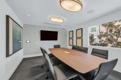 a conference room with a wooden table and chairs at Global Luxury Suites in LA's Seaside in Los Angeles