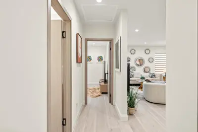 a hallway leading to a living room with a tub at Modern New 3B Home Fully Stocked & Cozy & Sunlight