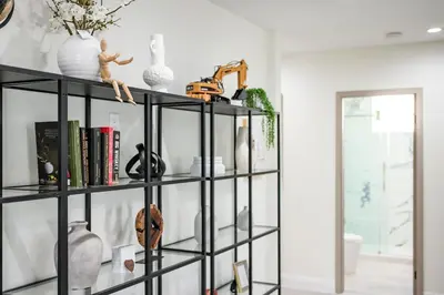 a black book shelf filled with vases and books at Modern New 3B Home Fully Stocked & Cozy & Sunlight
